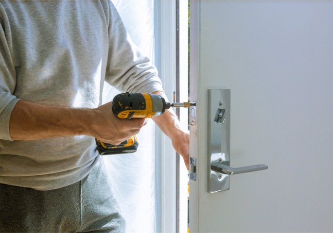 A handyman fixing a door handle during Door Replacement & Installation in Central Florida